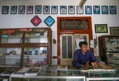 Muhammad atau dengan sapaan akrab Mamat (52) seorang pegawai Toko Buku Peneleh  melayani pengunjung yang datang ke tokonya. Toko ini buka setiap hari Senin-Sabtu pada pukul 08.00-16.00 WIB. Sayangnya, toko ini kerap kali sepi pembeli, kecuali awal tahun dan akhir tahun karena toko ini aktif menjual kalender tiap tahunnya. (foto: Sahirol Layeli)