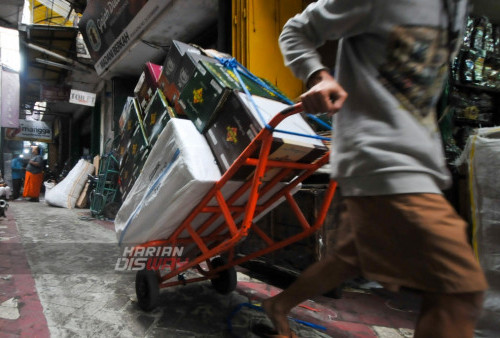 Pekerja mengangkut busana muslim di Pasar Bong, Surabaya, Jawa Timur, Sabtu (8/4/2023). Penjualan busana muslim seperti, sarung, jilbab, mukena, dan sajadah di pasar tersebut selama Ramadhan tahun ini mengalami penurunan hingga 60 persen dibanding Ramadhan tahun lalu. (foto: Julian Romadhon)