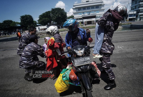 Prajurit TNI AL membantu pemudik yang hendak kembali ke Kota asal saat naik KRI Banjarmasin-592 di Dermaga Ujung Koarmada II, Surabaya, Jawa Timur, Selasa (25/4/2023). Sebanyak 170 pemudik yang mengikuti program mudik gratis kembali naik kapal perang TNI Angkatan Laut KRI Banjarmasin-592 dari Surabaya menuju Semarang dan Jakarta. (foto: Julian Romadhon) 
