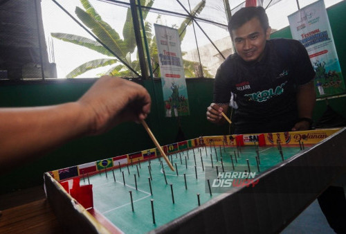 Panitia dari Kampoeng Dolanan menunjukan cara bermain sepak bola paku pada Festival Permainan Tradisional di BPMP Jawa Timur, Surabaya, Jawa Timur, Selasa, 24 Oktober 2023. Berbagai macam permainan tradisional seperti Sepak Bola Paku, Kelereng, Bakiak Raksasa, Balap Karung dan Kopral yang diikuti pelajar sekolah dasar dalam rangka Mengampanyekan Sekolah Sehat tersebut untuk menumbuhkan dan melestarikan permainan tradisional anak yang terkandung nilai-nilai kebersamaan sosial dan kreativitas. (Julian Romadhon/Harian Disway) 

