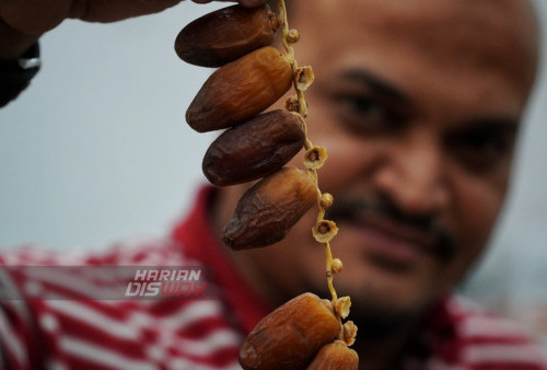 Pemilik Toko Lawang Agung, Zuhair Salim, menunjukan salah satu jenis kurma dari Tunisia, Palem Frutt saat berada di Toko miliknya di kawasan wisata religi Masjid Sunan Ampel, Surabaya, Jawa Timur, Selasa (28/3/2023). (foto: Julian Romadhon).
