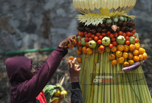 Warga berebut hasil bumi saat berlangsungnya sedekah bumi di Made, Sambikerep, Surabaya, Jawa Timur, Minggu, 15 Oktober 2023. Sedekah Bumi atau ruwat desa dengan 4 gunungan hasil bumi berukuran raksasa itu digelar sebagai wujud rasa syukur kepada tuhan yang maha esa atas rizki yang diberikan kepada para warga Made, Sambikerep. (Julian Romadhon/Harian Disway)