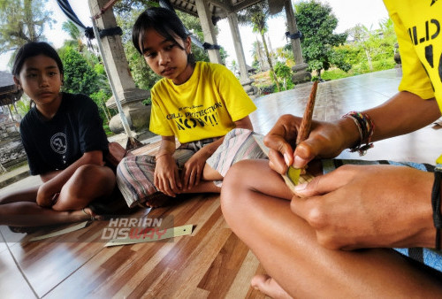 Dua koordinatornya, Putu Marsellia Putri dan Dewa Ayu Dyah Laksmi, dari Alit Indonesia Bali, membimbing anak-anak itu di ruang Jabe Pura Dalem Agung, atau balai di halaman depan Pura Dalem Agung, Tampak Siring, Bali.