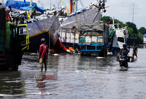 Pekerja melakukan masih melakukan proses bongkar muat saat terjadinya banjir rob atau banjir di tepi pantai karena permukaan air laut yang lebih tinggi daripada bibir pantai atau daratan di pesisir pantai Pelabuhan Kalimas, Surabaya, Jawa Timur, Rabu (18/5). Sebagian dermaga kawasan Pelabuhan Kalimas tergenang banjir rob akibat pasang air laut yang tinggi, namun aktifitas bongkar muat di lokasi tersebut masih berjalan normal. Foto: Julian Romadhon