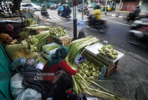 Para pedagang cangkang ketupat menunggu para pembeli cangkang di Jalan Pandegiling Surabaya, Jawa Timur, Selasa (25/4/2023) jelang lebaran ketupat. Menjelang tradisi Lebaran ketupat banyak warga membeli cangkang ketupat yang terbuat dari daun kelapa muda itu dijual dengan harga 10 ribu per ikat berisi 10 cangkang. (foto: Julian Romadhon)