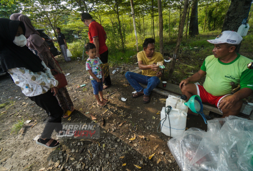 Penderes (petani air sadapan) Suriaman menjual air sadapan (legen) di Hendrosari, Menganti, Gresik, Jawa Timur, Rabu (11/5). Dalam sehari pembuat Legen asli hanya bisa menghasilkan antara 20 liter hingga 30 liter legen tergantung produktifitas dan usia pohon siwalan yang dipanjat. Air sadapan (legen) dapat dikonsumsi langsung atau digunakan sebagai bahan baku pembuatan tuak dijual berkisar Rp. 20 ribu per satu setengah liternya. Foto: Julian Romadhon