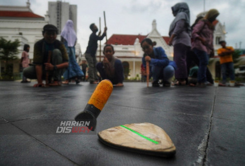 Sejumlah anak mencoba permainan tradisional Balogo asal Kalimantan sambil menunggu waktu berbuka puasa (ngabuburit) di Alun-alun Surabaya, Jawa Timur, Minggu (26/3/2023). Ngabuburit dengan bermain permainan tradisional bersama Komunitas Kampoeng Dolanan Surabaya itu sekaligus mengkampanyekan beragam permainan tradisional serta mengingatkan kembali tentang sebuah tradisi ngabuburit positif dalam lingkungan anak-anak. (foto: Julian Romadhon)
