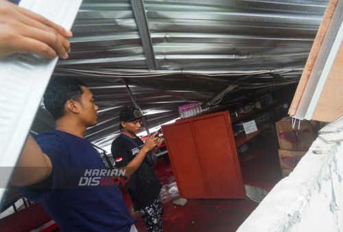 Pemilik warung di Sentra Kuliner Bunderan Aloha, Adam Haris melakukan evakuasi tempat usaha miliknya pasca Hujan deras yang disertai angin kencang yang mengakibatkan bangunan Sentra Kuliner di wilayah tersebut roboh.