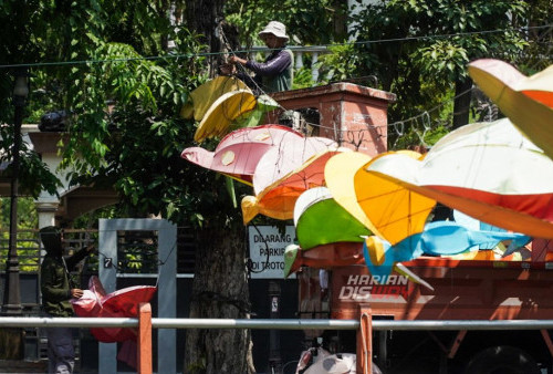 Petugas dari Dinas Kebersihan dan Ruang Terbuka Hijau (DKRT) Kota Surabaya memasang lampion yang melintang di atas Sungai Kalimas, Surabaya, Jawa Timur, Jumat, 3 November 2023. Pemasangan lampion kota baru yang berbentuk hewan itu menggantikan yang lama untuk menambah keindahan kawasan wisata Sungai Kalimas terutama pada malam hari. (Julian Romadho/Harian Disway) 