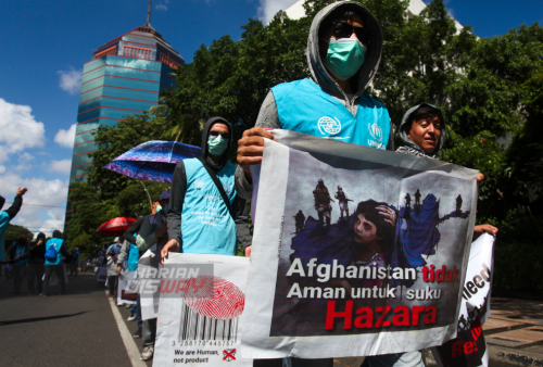 Sejumlah pengungsi asal Afghanistan melakukan aksi jalan kaki di jalan Basuki Rahmat, Embong Malang, Bubutan hingga jalan Pahlawan, Surabaya, Jawa Timur, Selasa, 24 Mei 2022. Dalam aksi jalan kaki tersebut mereka meminta kejelasan status dan kepastian untuk berangkat ke negara ketiga setelah lama tinggal di pengungsian. Foto: Julian Romadhon 