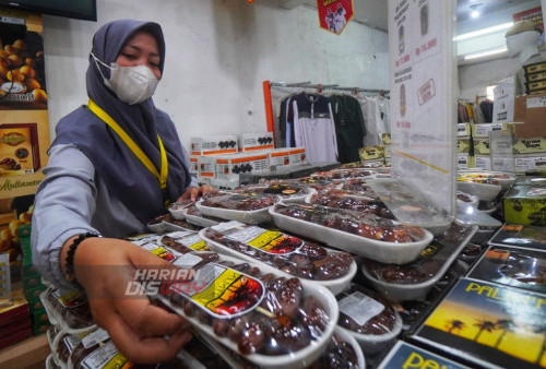 Penjaga Toko, Sevin, menata tumpukan kemasan kurma di Toko bernuansa Timur Tengah, yang menjual sebanyak 27 jenis kurma, Lawang Agung Surabaya, Jawa Timur, Selasa (28/3/2023). (foto: Julian Romadhon)