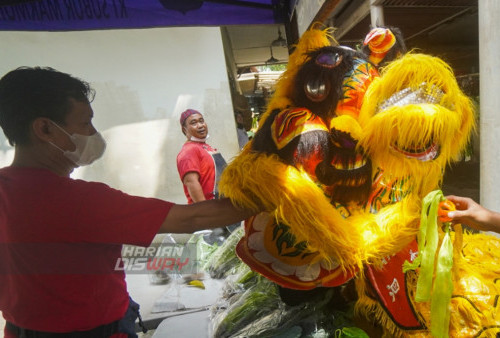 Pedagang di Pasar Moderen, Fresh Market Citraland memberikan angpau pada Barongsai yang menghibur para pengunjung dan pedagang yang berada di Fresh Market Citraland, Surabaya, Jawa Timur, Sabtu (21/1/2023). Atraksi Barongsai tersebut untuk menghibur para pengunjung pasar selama satu minggu kedepan untuk memperingati Tahun Baru Imlek 2023. Pertunjukan atraksi Barongsai tersebut digelar oleh pengelola Fresh Market Citraland hingga perayaan Cap GO Meh.