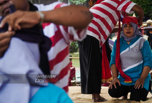 Dua pegulat wanita, Dian menggunakan iket kepala berwarna merasa ketika mengikuti Gulat Okol di Lapangan Persahabatan Kampus Universitas Wijaya Kusuma (UWK) Surabaya, Jawa Timur, Selasa (20/6/2023). Gulat tradisional atau yang lebih dikenal dengan Gulat Okol, olahraga Gulat asal Gresik, Jawa Timur itu menjadi bagian dari hari jadi Universitas Wijaya Kusuma Surabaya (UWKS) ke 42, tersebut merupakan wujud kegembiraan pihak UWKS atas mendapatkan posisi ke 3 terbaik se-Surabaya dan ke 7 se-Jatim.