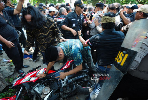 Sekelompok orang  berusaha menghalau petugas kepolisian saat eksekusi pengosongan bangunan di jalan Gading Pantai II/12 Surabaya, Jawa Timur, Rabu, 11 Oktober 2023. Eksekusi satu unit bagunan rumah yang dilakukan oleh Pengadilan Negeri Kota Surabaya tersebut sempat berlangsung ricuh karena mendapatkan perlawanan dari sekelompok orang sehingga polisi melakukan tindakan penghalauan. (Julian Romadhon/Harian Disway)