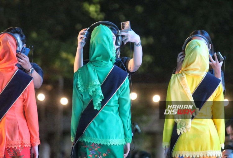 Panitia memasangkan headset pada peserta empat besar Cak dan Ning Surabaya selama mereka menunggu giliran menjawab pertanyaan dari panelis. Dengan diputarkan musik, Tiga peserta yang lain tidak bisa mendengarkan pertanyaan yang diakukan oleh panelis kepada satu peserta saat menjalani sesi tanya jawab. Materi pertanyaan adalah , apa yang akan dilakukan bila peserta tersebut terpilih menjadi Cak dan Ning Surabaya 2025.  Jawaban ini sangatlah penting mengingat Cak dan Ning yang  diharapkan menjadi influencer yang menyebarkan semangat cinta budaya, cinta lingkungan, dan cinta kotanya…Surabaya.
Foto: Boy Slamet-Harian Disway 