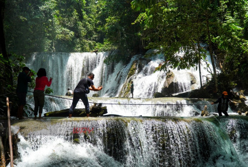 Pengunjung melintasi Air Terjun Piala dengan menggunakan tambang. Wisata alam Air Terjun Piala merupakan wisata andalan daerah tersebut yang jaraknya hanya di tempuh 10 menit dari pusat kota Luwuk, tak hanya itu Air Terjun ini dijadikan sebagai sumber pembangkit listrik oleh pihak PLN. Sehingga di dekat air terjun ini terdapat PLTMH yaitu pembangkit listrik yang menggunakan tenaga mini hidro. (foto: Julian Romadhon)