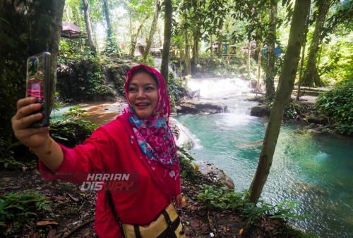 Pengunjung berselfi dengan latar belakang keindahan air terjun Salodik di Luwuk, Banggai, Sulawesi Tengah, Jumat (17/3/2023). Wisata alam Air Terjun Salodik merupakan wisata yang mempesona dengan Spot foto, bebatuan bertingkat serta air yang jernih. Wisata Air Terjun Salodik tersebut yang jaraknya dapat ditempuh 1 jam dari pusat kota Luwuk. (foto: Julian Romadhon)