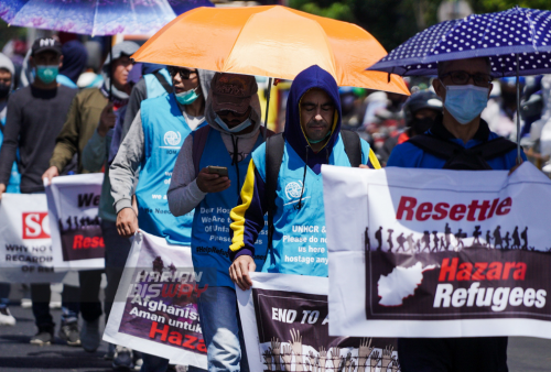 Sejumlah pengungsi asal Afghanistan melakukan aksi jalan kaki di jalan Basuki Rahmat, Embong Malang, Bubutan hingga jalan Pahlawan, Surabaya, Jawa Timur, Selasa, 24 Mei 2022. Dalam aksi jalan kaki tersebut mereka meminta kejelasan status dan kepastian untuk berangkat ke negara ketiga setelah lama tinggal di pengungsian. Foto: Julian Romadhon 