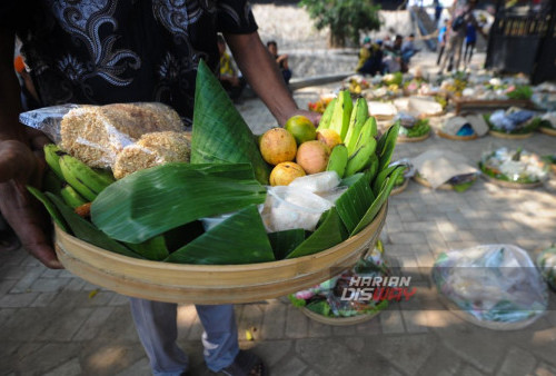 Warga membawa tumpeng yang diletakan di Punden Mbah Singo Joyo, Made, Sambikerep, Surabaya, Jawa Timur, Minggu, 15 Oktober 2023. Sedekah Bumi atau ruwat desa dengan 4 gunungan hasil bumi berukuran raksasa itu digelar sebagai wujud rasa syukur kepada tuhan yang maha esa atas rizki yang diberikan kepada para warga Made, Sambikerep. (Julian Romadhon/Harian Disway)
