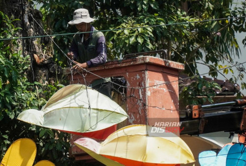 Petugas dari Dinas Kebersihan dan Ruang Terbuka Hijau (DKRT) Kota Surabaya memasang lampion yang melintang di atas Sungai Kalimas, Surabaya, Jawa Timur, Jumat, 3 November 2023. Pemasangan lampion kota baru yang berbentuk hewan itu menggantikan yang lama untuk menambah keindahan kawasan wisata Sungai Kalimas terutama pada malam hari. (Julian Romadho/Harian Disway) 