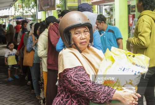 Warga membawa beras yang berada di atas motor hasil dari pasar murah di halaman Rusun Penjaringan Sari Surabaya Jawa Timur, Kamis 1 Februari 2024. Pasar murah yang digelar Dewan Ketahanan Pangan dan Pertanian (DKPP) Surabaya tersebut menjual sejumlah bahan pokok murah beberapa diantaranya telur ayam san beras medium dengan harga Rp. 51.500/5 kg dan premium dengan harga 69.500/5 kg. (Moch Sahirol/Harian Disway)