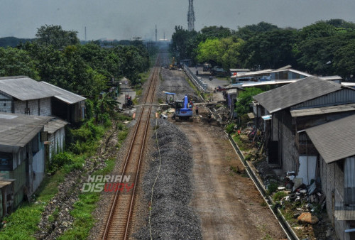 Nampak dari ketinggian pekerja mengoperasikan alat berat saat melakukan proses pembenahan Rel Ganda di Trosobo, Sidoarjo, Jawa Timur, Jumat (10/3/2023). Proyek Pembenahan Rel Ganda milik PT KAI tersebut dikerjakan disepanjang jalur Sidoarjo-Mojokerto yang bertujuan untuk mendukung mobilitas masyarakat di wilayah setempat. (foto: Syahrul Rozak Yahya)
