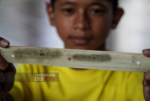 I Kadek Dwi Fadli Mahadiki (13) menunjukan hasil tulisannya yang bertuliskan Puan Kinasih Gusti dengan Aksara Bali di Daun Lontar.