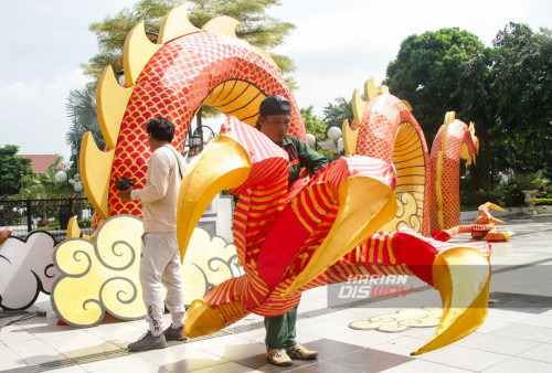 Pekerja tengah mendekorasi liong naga dalam menyambut perayaan Imlek di depan Taman Surya Balai Kota Surabaya, Jawa Timur, Kamis 1 Februari 2024. Ornamen naga kayu dengan panjang 20 meter dan tinggi 6 meter itu mempercantik Kota Surabaya dalam rangka menyambut perayaan Imlek tahun 2024. (Moch Sahirol/Harian Disway)