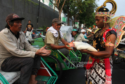 Prajurit TNI Angkatan Darat berbakaian tokoh perwayangan, Gatotkaca membagikan bantuan paket berupa beras kepada tukang becak di Wonokromo, Surabaya, Jawa Timur, Senin, 11 Desember 2023. Pembagian paket beras sebanyak 250 paket dengan berat per paket 5 kilogram itu untuk membantu meringankan ekonomi para tukang becak di kawasaan tersebut sekaligus untuk memperingati HUT ke-78 Yonif 516/CY Kodam V/Brawijaya. (Julian Romadhon/Harian Disway)