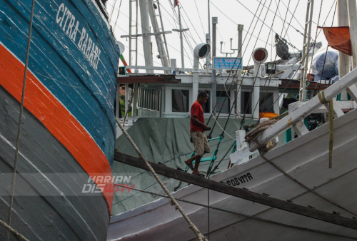 Pekerja turun dari kapal yang bersandar di pelabuhan tradisional Kalimas Surarabaya, Jawa Timur, Minggu (1/5). Saat ini ekspedisi via kapal layar motor mulai didominasi oleh sejumlah kebutuhan rumah tangga untuk menyambut lebaran. Foto: Julian Romadhon