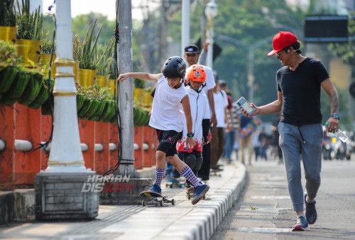 Ivander Drago Setiawan (10) bermain Skateboard ditemani sang ayah Evan Setiawan melintasi Jalan Ketapang Kali, Surabaya, Jawa Timur, Rabu (21/6/2023). Puluhan pecinta skateboard tersebut melakukan konvoi keliling kota untuk memperingati Skateboard World Day 2023.