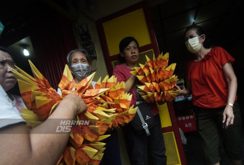 Umat Buddha membawa Kimcua yang dibentuk menjadi bunga teratai untuk dibakar dalam ritual tradisi Ceng Beng yang digelar di  Tempat ibadah umat Buddha Mahayana yang tergabung dalam Cetiya Buddha Dhamma Sangha Lotus, Surabaya, Jawa Timur, Rabu (5/4/2023). Ritual Tradisi sembahyang arwah Ceng Beng atau Qing Ming, merupakan ritual tradisi bagi warga Tionghoa untuk mendoakan arwah para leluhur mereka. (foto: Julian Romadhon)
