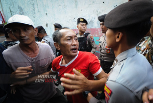 Saling dorong antara petugas dengan warga saat berlangsungnya eksekusi 28 Rumah di Dukuh Pakis, Surabaya, Rabu, 9 Agustus 2023. Pengadilan Negeri Kota Surabaya mengeksekusi sebanyak 28 unit rumah setelah adanya putusan gugatan oleh Wenny Untari kepada Sidik Dewanto tergugat pada obyek sengketa lahan seluas 2 hektar yang terletak di belakang Dukuh Pakis Surabaya. (Julian Romadhon/Harian Disway)