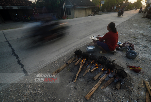 Aminah penjual makanan tradisional serabi melakukan jual beli di tepi jalan Kradenan Blora, Jawa Tengah, Rabu (4/5). Makanan ini terkenal di Jawa, juga di Indonesia. Secara umum, serabi dibagi atas rasa, ada yang nis dengan memanfaatkan gula merah atau kinca dan kedua adalah serabi asin yang memanfaatkan oncom yang ditaruh dan ditaburkan di atasnya. Secara umum, serabi disebut makanan ringan yang hampir mirip seperti pancake. Foto: Julian Romadhon
