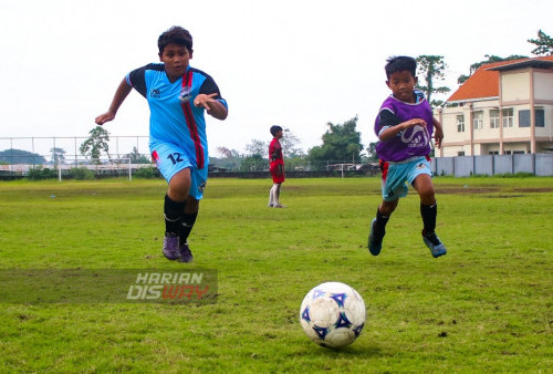 Nadhif, murid SSB Mulyorejo dengan nomor punggung 12 (kiri) dan Faris, nomor punggung 8 (kanan) mengejar bola saat latihan di Lapangan Mulyorejo, Surabaya, Jawa Timur. Minggu (5/3/2023). (Foto: Moch Sahirol Layeli)