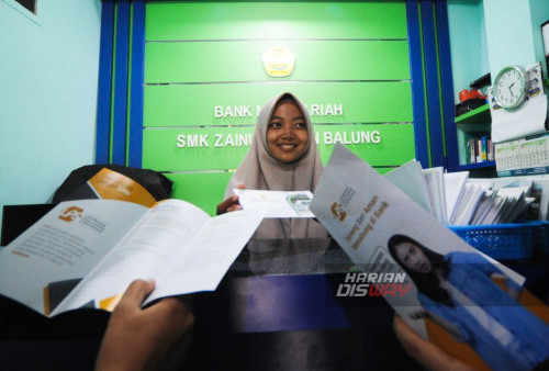 Teller Bank Mini Syariah, Arini Maulidya melayani nasabah bank mini SMK Zainul Hasan Balung, Jember, Jawa Timur, Jumat, 18 Agustus 2023. Lembaga Penjamin Simpanan (LPS) terus melakukan Sosialisasi sebagai upaya meningkatkan kepercayaan terhadap perbankan kepada masyarakat terkait izin usaha yang dicabut oleh Otoritas Jasa Keuangan (OJK). (Julian Romadhon/Harian Disway)
