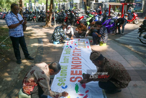 Anggota Komunitas sepeda tua Senopati saat melukis batik diatas kain putih yang berlangsung di depan taman Taman Mayangkara, Surabaya, Jawa Timur, Minggu 1 Oktober 2023 pagi. Komunitas Sepeda Kuno Patriot Sejati (Senopati) melukis batik di atas kain putih sepanjang 5 meter bertuliskan Selamat Hari Batik Nasional Senopati yang berlangsung di Car Free Day (CFD) Jalan Darmo, tepatnya di depan Taman Mayangkara, Surabaya. Melukis batik yang diikuti oleh 25 Anggota Komunitas Senopati melukis menggunakan cat air dengan lima warna bermotif mega mendung, Bali lung, daun kembang tanjung, hingga kawung. Melukis batik yang diadakan ini sebagai wujud kepedulian terhadap warisan budaya Indonesia dan dalam rangka memperingati Hari Batik Nasional yang jatuh pada tanggal 2 Oktober 2023. (Moch Sahirol/Harian Disway)