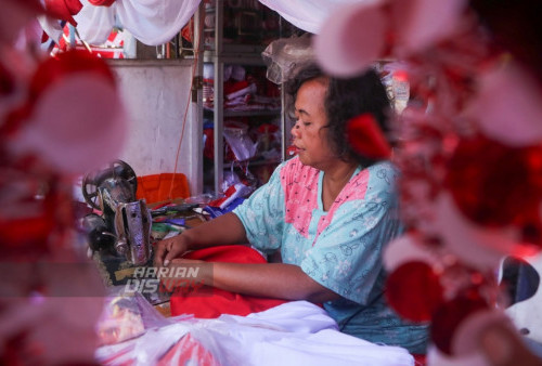 Penjual Bendera Musiman menjahit bendera di kampung bendera yang terletak di Jalan Darmo kali, Surabaya, Jawa Timur. Senin, 7 Agustus 2023. Bendera dan umbul-umbul yang dijual di kampung bendera tersebut memiliki harga yang bervariatif, dari harga Rp 5 ribu hingga Rp 60 ribu rupiah tergantung jenis dan ukurannya. (Moch Sahirol/Harian Disway)