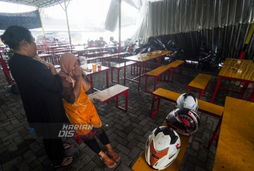 Pemilik warung Ayam Geprek, Tri Amini, menangis melihat kondisi warungnya yang berada di Sentra Kuliner tersebut roboh akibat hujan disertai angin kencang melanda kawasan Aloha, Sidoarjo.
