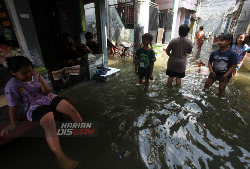 Warga melintasi genangan air di kampung Kalianak Surabaya, Jawa Timur, Rabu (5/7/2023). Banjir Rob yang tinggi itu adanya fase bulan purnama yang menyebabkan sejumplah perkampungan padat penduduk di kawasan tersebut tergenang air laut.