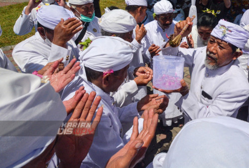 Pandita mepercikan air suci kepada umat Hindu yang mengikuti Upacara Melasti di Kenjeran, Surabaya, Jawa Timur, Minggu (19/3/2023). Upacara Melasti bertujuan menyucikan diri dan alam tersebut dilakukan untuk menyambut Hari Raya Nyepi Tahun Baru Saka 1945 yang jatuh pada Rabu (22/3). (foto: Andika Bagus Priambodo)