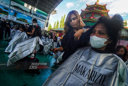 Kapster, Olive memangkas rambut kepada warga di Masjid Muhammad Cheng Hoo, Surabaya, Jawa Timur, Senin (10/4/2023). Kegiatan berbagi dan potong rambut massal secara gratis dalam bulan Ramadhan yang digelar oleh Ngaji Komunitas Salon (Ngasal) Surabaya tersebut itu diikuti sekitar 500 orang anak yatim dan Duhafa. (foto: Julian Romadhon)