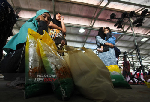 Warga terlelah usai mengantri untuk membeli bahan pangan saat digelarnya Gerakan Pangan Murah di Pasar Induk Surabaya Sidotopo (PISS), Surabaya, Jawa Timur, Senin (26/6/2023). Pemerintah Kota Surabaya menggelar program Gerakan Pangan Murah dengan menjual bahan pangan dengan harga lebih murah dari pasaran, hal itu sebagai upaya untuk mengendalikan inflasi dan menstabilkan pasokan bahan pangan menjelang Hari Raya Idul Adha.  