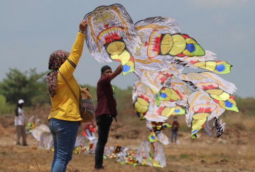 Layang layang berbentuk kepala Reyog tampak bersiap diterbangkan. Rangkaian layang layang berupa kepala-kepala Reyog itu merupakan karya peserta dari kelompok Petung yang berasal dari Kabupaten Tulungagung 