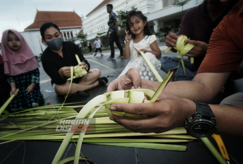 Jemari lincah Mustofa menganyam cangkang ketupat bersama warga yang berkunjung di Alun-alun Surabaya, Komplek, Balai Pemuda Surabaya, Jawa Timur, Kamis (27/4/2023). Pembelajaran membuat cangkang ketupat tersebut diinisiasi Kampoeng Dolanan (KD) dengan tujuan anak-anak dan warga mampu menganyam sendiri janur menjadi ketupat sehingga tradisi membuat ketupat untuk Lebaran Ketupat tetap terjaga. (foto: Julian Romadhon)
