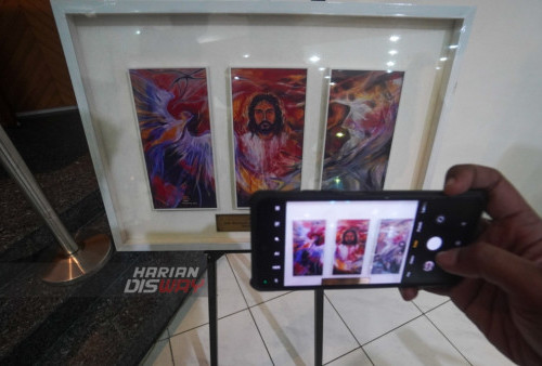 Pengunjung mendokumentasikan sebuah lukisan yang dilukis oleh tiga pelukis sekaligus saat berlangsungnya pameran yang bertajuk Ijol Charity, Painting Exhibition yang digelar di Gedung Pertemuan Gereja Kristen Indonesia (GKI) Darmo Satelit (Dasa), Surabaya, Jawa Timur, Jumat (20/1/2024) malam.Pameran yang bertajuk Ijol Charity, Painting Exhibition tersebut diikuti sebanyak dua puluh tujuh lukisan karya Pendeta, Hosea Abdi Widhyadi. Kegiatan tersebut berlangsung selama satu bulan, dimulai dari tanggal 21 Januari 2023 dengan dua tempat lokasi yang berbeda, lokasi pertama di GKI Dasa Surabaya dan lokasi kedua di GKI Manyar Surabaya. Hasil dari kegiatan ini akan disumbangan langsung ke Gereja-gereja yang membutuhkan melalui Gereja Kristen Indonesia Sinode Wilayah Jatim.