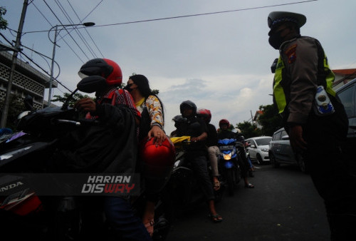 Polisi mengatur lalin (lalulintas) di depan Kantor Perwakilan Bank Indonesia (BI) Provinsi Jawa Timur di Surabaya, Jawa Timur, Minggu (26/3/2023). Kantor Perwakilan Bank Indonesia (BI) Provinsi Jawa Timur membuka gerai layanan penukaran Uang Baru Secara Lantur melalui Kick Off Semarak Rupiah Ramadhan dan Berkah Idul Fitri (SERAMBI) 2023, dengan sebanyak 24,5 Triliun Rupiah pada setiap hari Sabtu dan Minggu di bulan Ramadhan untuk memenuhi kebutuhan uang baru di masyarakat. (foto: Julian Romadhon)