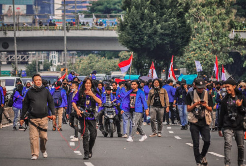 Para mahasiswa melakukan long march dari arah Senayan menuju gedung DPR RI dalam aksi unjuk rasa 11 April 2022