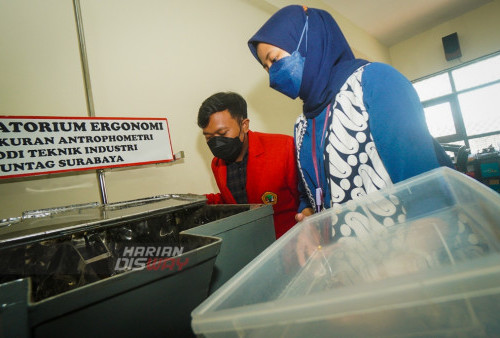 Agus Rianto (jas merah) dan Lutfi Rahman Fadila mahasiswa program studi (prodi) Teknik Industri yang akan diwisuda pada 4 September mendatang menunjukan alat mesin pencampur ragi dengan kedelai untuk home industry atau Usaha Mikro, Kecil dan Menengah (UMKM) tempe di Universitas 17 Agustus 1945 (Untag) Surabaya, Jawa Timur, Kamis 1 September 2022. Inovasi yang dilakukan ini berawal dari keprihatinan terhadap hasil produksi tempe dari UMKM yang telah dijalani secara turun temurun sejak tahun 1980-an ini tidak maksimal. Untuk meningkatkan kualitas tempe dan pendapatan UMKM Agus dan Lutfi, berhasil mengembangkan alat pencampur ragi dan kedelai dengan bahan yang lebih higienis serta kapasitas lebih besar. Kedepannya keduanya memiliki target alat mixer ini dapat diproduksi secara massal.
