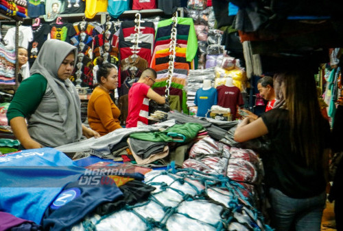 Pembeli memilih busana di pusat penjualan Pasar Kapasan, Surabaya, Jawa Timur, Minggu (9/4/2023). 
Penjualan busana di pasar Kapasan selama Ramadhan tahun ini mengalami penurunan hingga 65 persen dibanding Ramadhan tahun lalu. (foto: Moch Sahirol)

